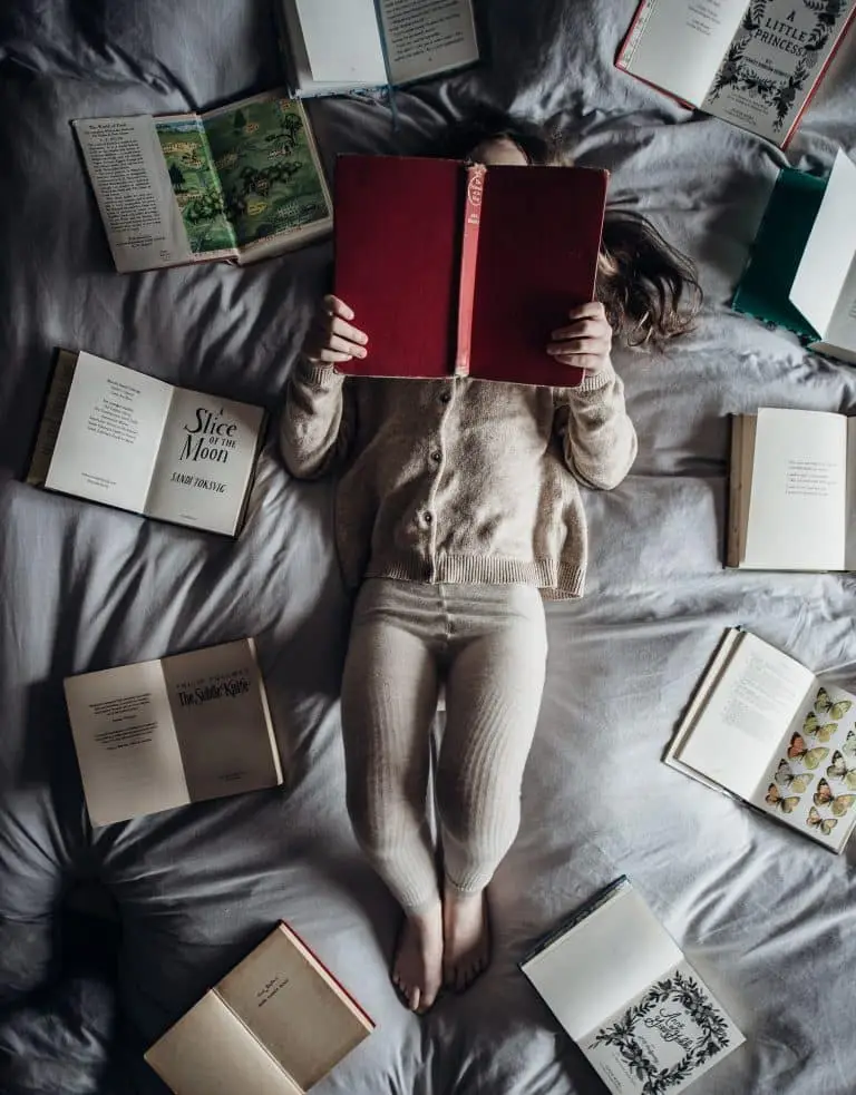 enfant entourée de livres et qui lit de annie-spratt